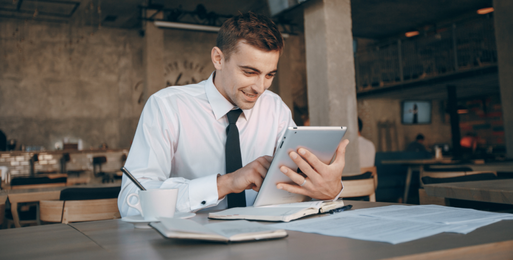 Profissional utilizando tablet em ambiente corporativo com gerenciamento de dispositivos móveis (MDM)