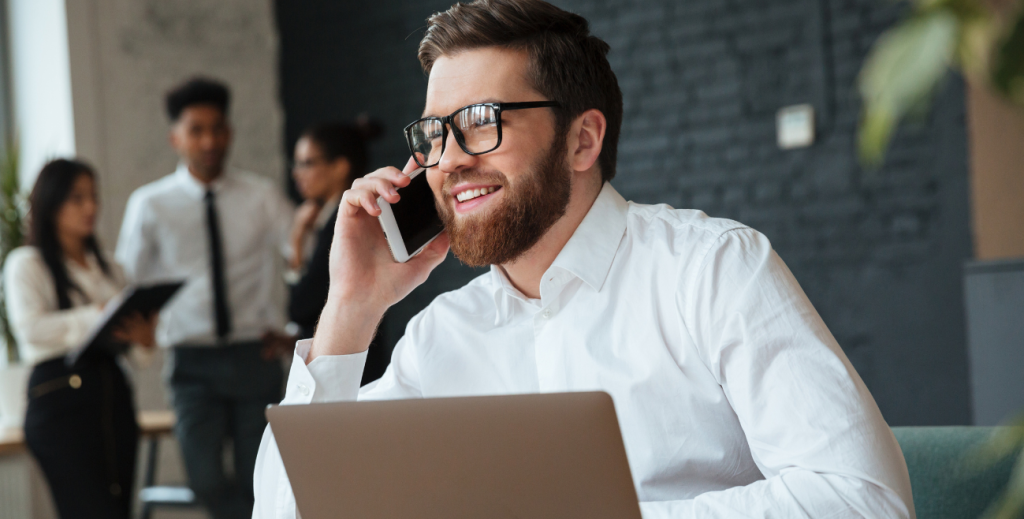 Funcionário utilizando smartphone e notebook corporativo gerenciado por solução de MDM para controle e segurança de dispositivos móveis.