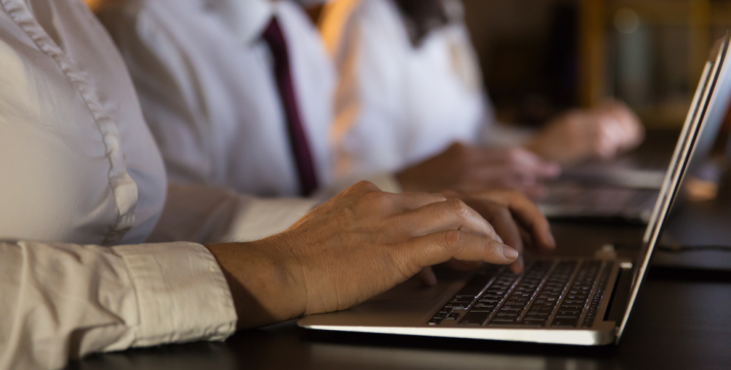 Profissional utilizando notebook para gerenciar dispositivos móveis com Cloud4Mobile