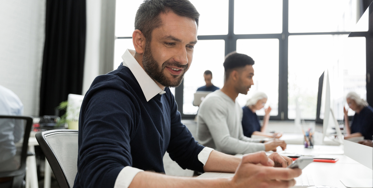 Profissional utilizando smartphone, ilustrando o uso de dispositivos móveis gerenciados por soluções de MDM como o cloud4mobile