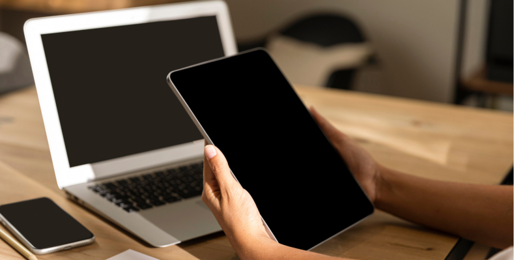 Profissional utilizando smartphone corporativo ao lado de notebook, representando soluções de MDM para desenvolvedores e gestão de dispositivos móveis em empresas