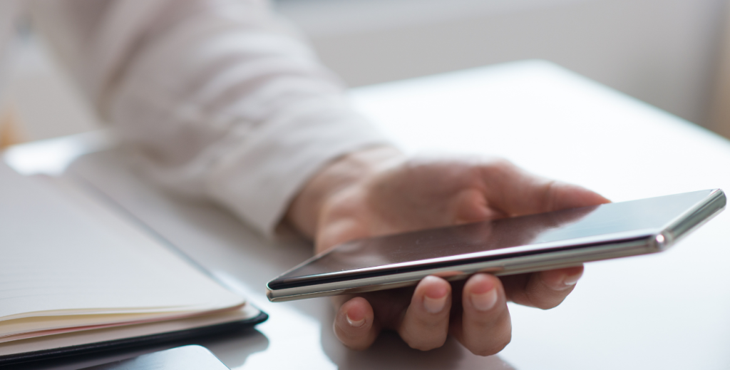 Segurança em dispositivos Android: smartphone corporativo sendo utilizado em ambiente de trabalho, com foco em proteção de dados e uso profissional controlado.