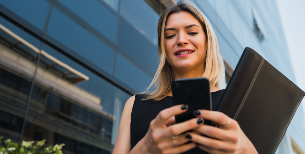 Mulher utilizando smartphone em ambiente externo com segurança de dispositivos móveis