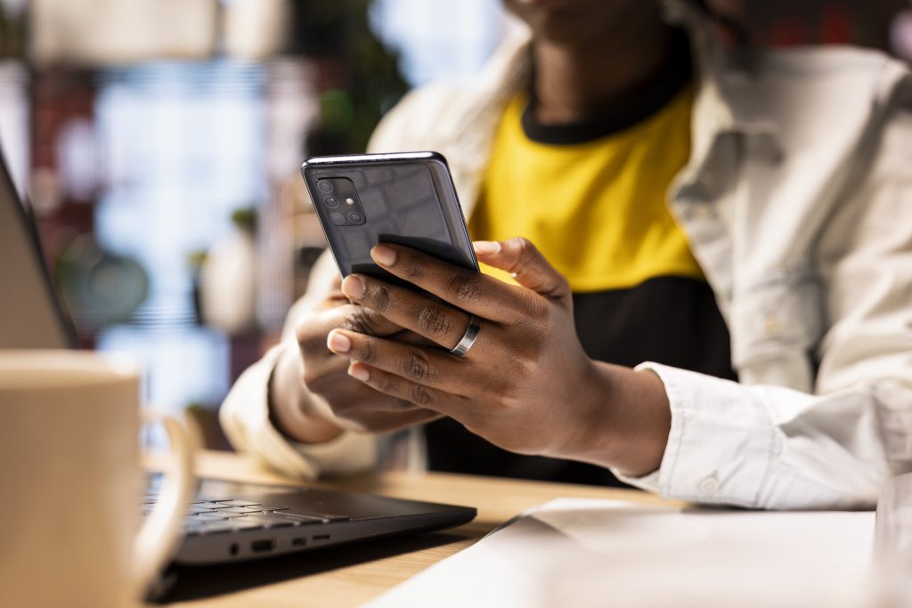 Profissional utilizando um celular corporativo para atividades de trabalho no escritório