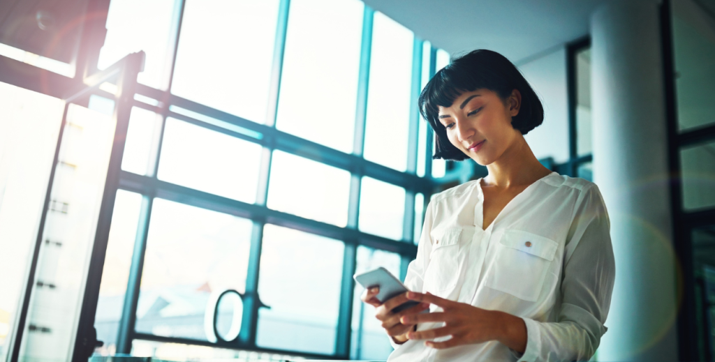 Profissional verificando inventário de celulares corporativos em ambiente empresarial