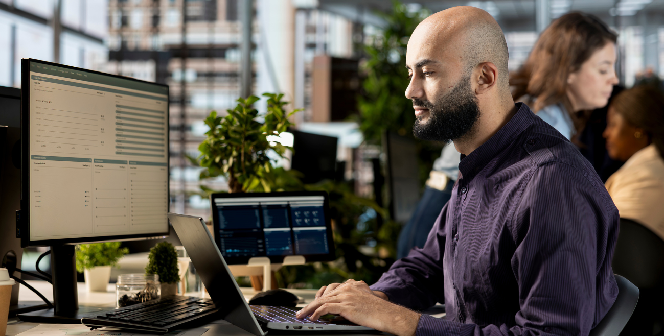 Profissional usando notebook no escritório com Samsung Knox ativo em dispositivo corporativo