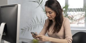 Profissional utilizando smartphone em ambiente corporativo relacionado à troca de MDM