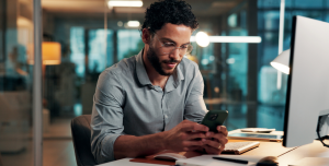 Gestor de TI comparando soluções Cloud4Mobile vs Intune no computador e smartphone no escritório