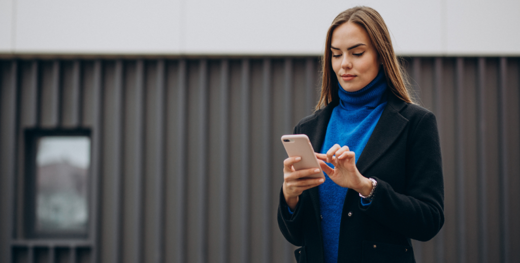 Profissional utilizando celular corporativo para rastreamento e monitoramento de dispositivos em campo.