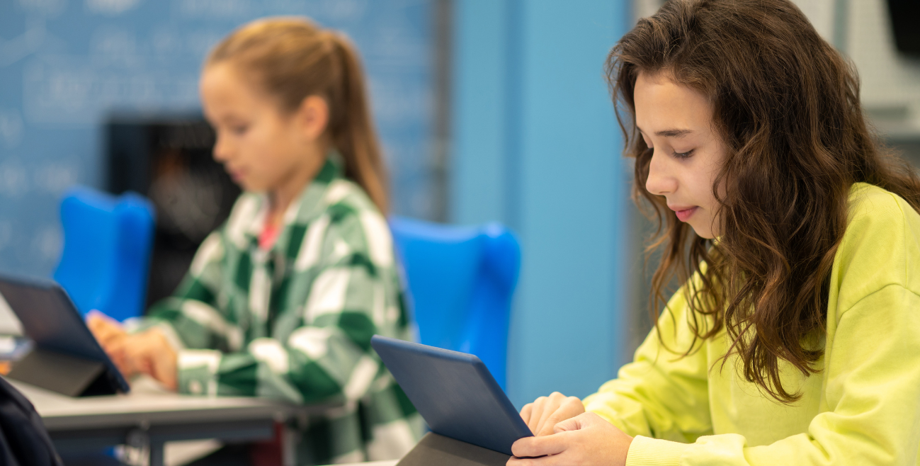 MDM para educação em escolas e universidades: alunas utilizando tablets em sala de aula, representando a gestão e o uso seguro de dispositivos móveis no ambiente educacional.