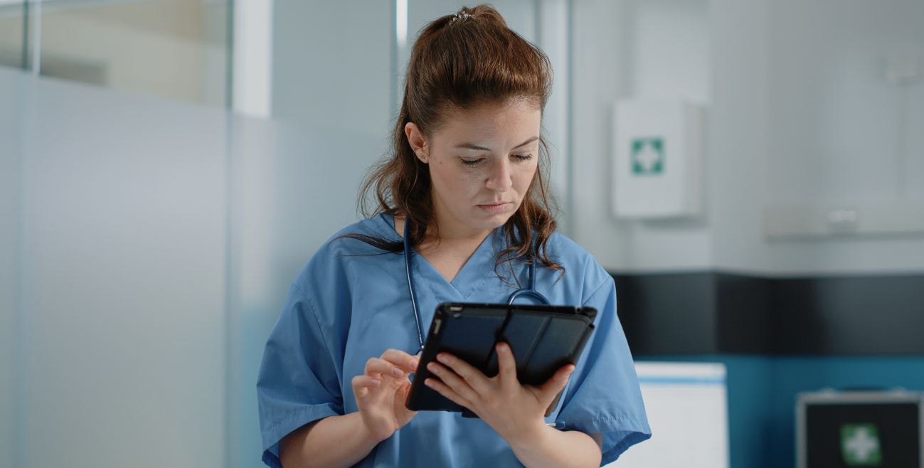Profissional em ambiente hospitalar utilizando tablet para gestão segura de dispositivos com MDM para saúde.