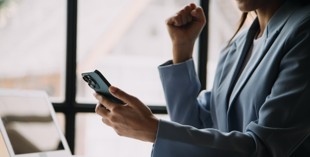 Profissional utilizando celular corporativo durante o trabalho, representando a implementação de uma política de celular corporativo para uso seguro e produtivo na empresa.