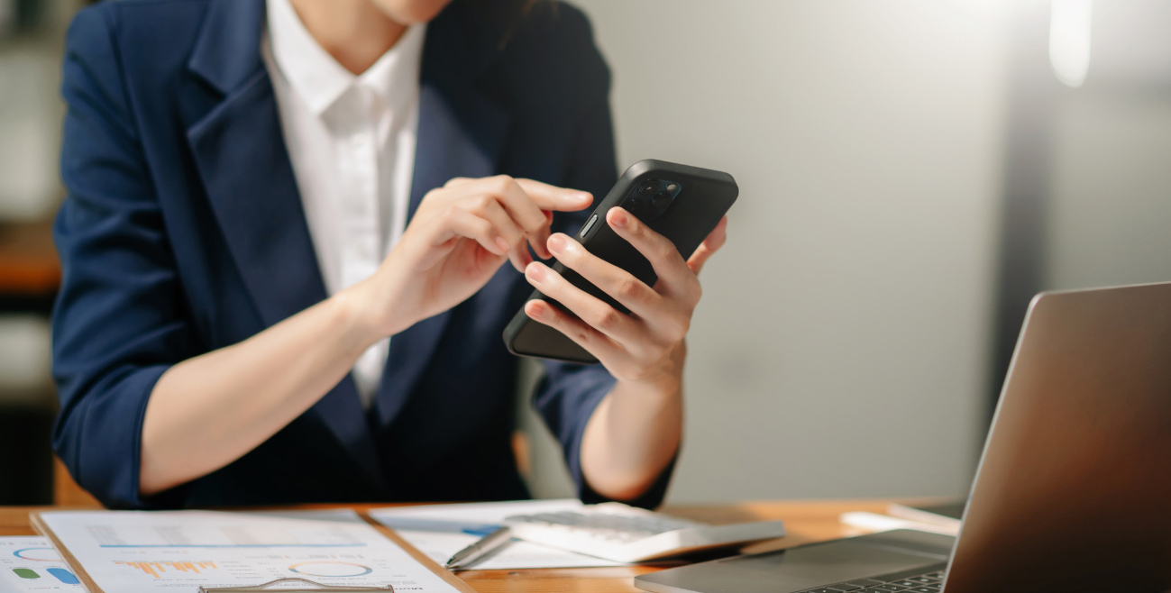 Profissional utilizando celular corporativo durante o trabalho, representando a implementação de uma política de celular corporativo para uso seguro e produtivo na empresa.
