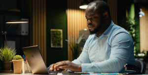 Colaborador trabalhando em notebook durante o gerenciamento de dispositivos corporativos organizados por subgrupos no MDM