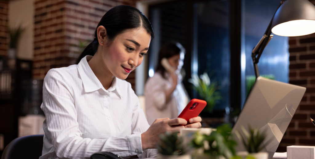 Profissional utilizando celular corporativo no trabalho, representando como controlar celular corporativo sem invadir a privacidade