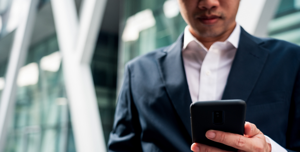 Profissional utilizando smartphone corporativo com perfil de trabalho Android, ilustrando a separação entre uso pessoal e corporativo no dispositivo.