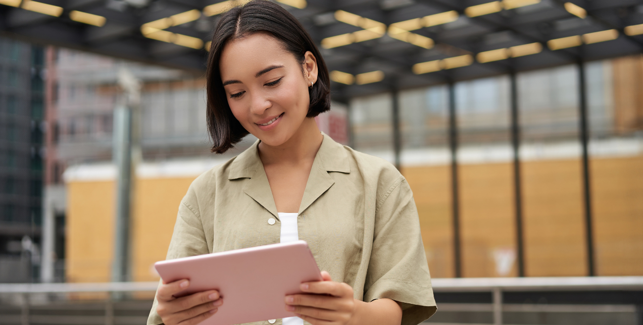 Uso pessoal de tablet corporativo em campo por colaboradora, ilustrando o uso indevido de dispositivo de trabalho.
