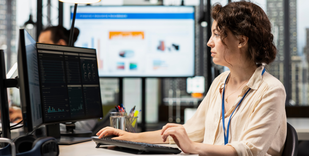 Profissional trabalhando em um computador corporativo para garantir a visibilidade do parque de dispositivos e o monitoramento em tempo real em um escritório